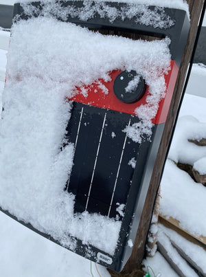 Solar Electric Fence Energizer / Charger covered in snow