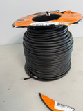 Spool of black gallagher underground fence cable with orange and black packaging on a light gray surface.