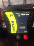 Patriot PMX200 mains energizer on a wooden surface with a blurred background