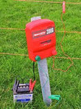 speedrite electric fence Unigizer connected to farm fence with green grass